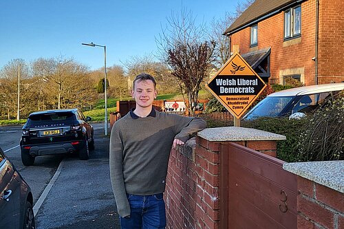 Dan Burton outside house with Welsh Liberal Democrat Garden Poster