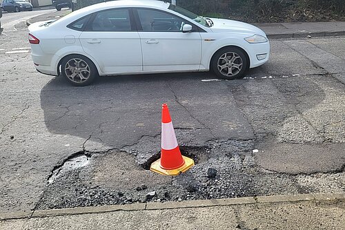 Traffic cone in a pothole